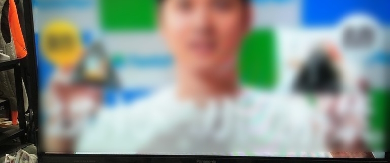 Panasonic製液晶テレビ TH-32E300 を正面から撮影した写真。リモコンがテレビ台の上に置かれ、作業スペース内に設置されている様子が分かる。