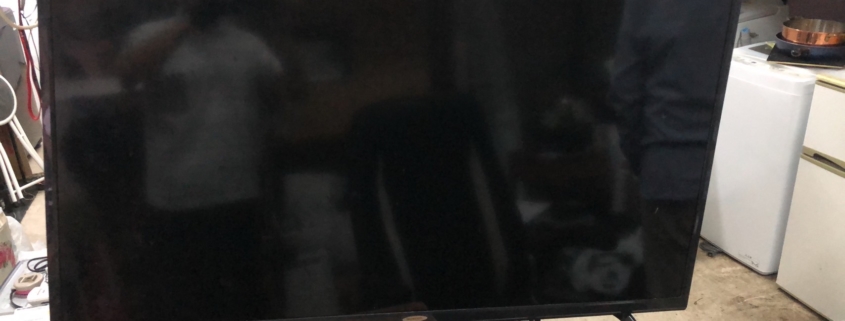 スカイワース製4K液晶テレビの正面写真。画面全体が黒く、前面中央にSkyworthロゴがある大型スマートテレビ