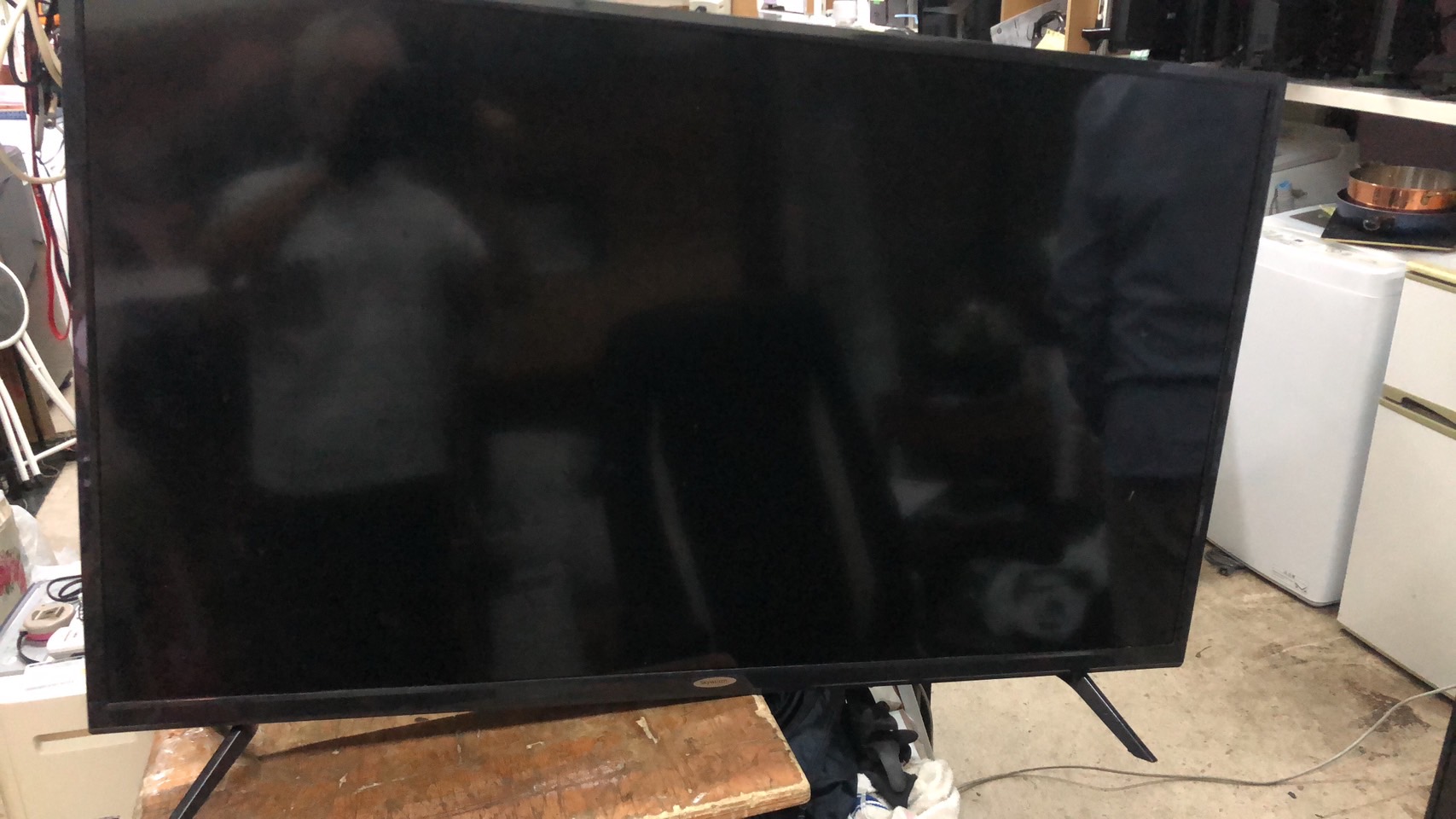 スカイワース製4K液晶テレビの正面写真。画面全体が黒く、前面中央にSkyworthロゴがある大型スマートテレビ